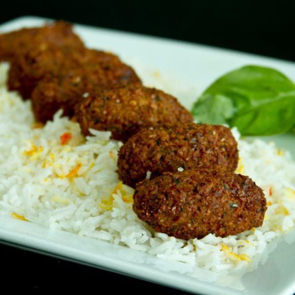Mimi's Kabob's falafel, served with white rice and garnished with a green leaf.