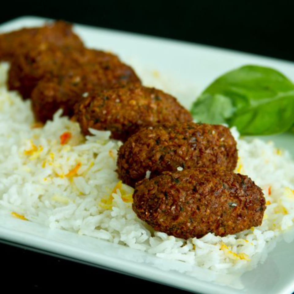 Mimi's Kabob's falafel, served with white rice and garnished with a green leaf.