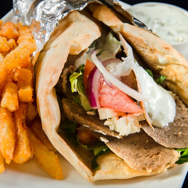 Mimi's Kabob gyro with meat, vegetables, feta, and sauce, served with golden french fries.
