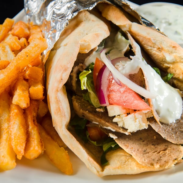 Mimi's Kabob gyro with meat, lettuce, tomato, onion, feta, and white sauce, served with fries.